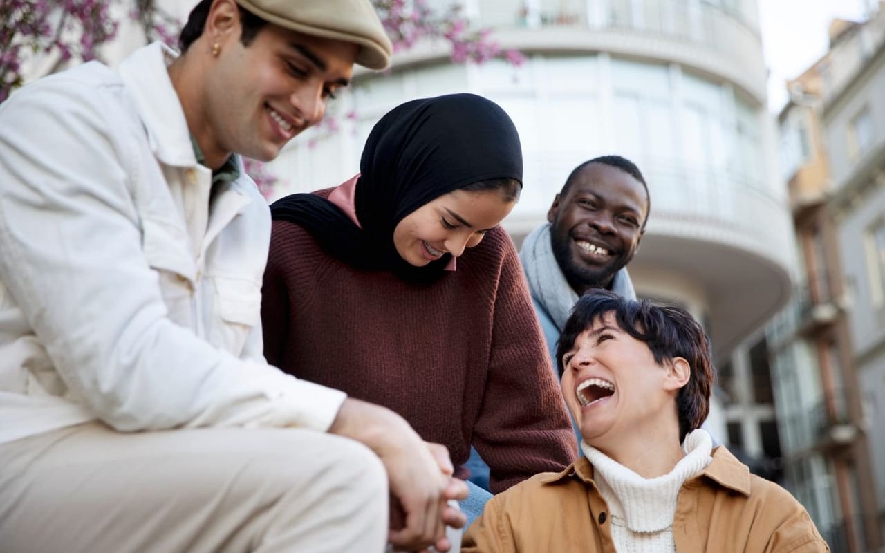 Un grupo de amigos conversa animadamente al aire libre.