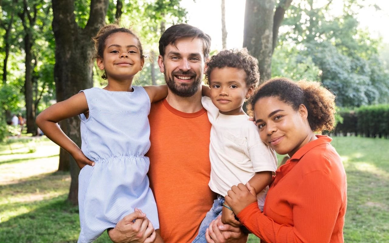 Una familia pasea junta por un parque.