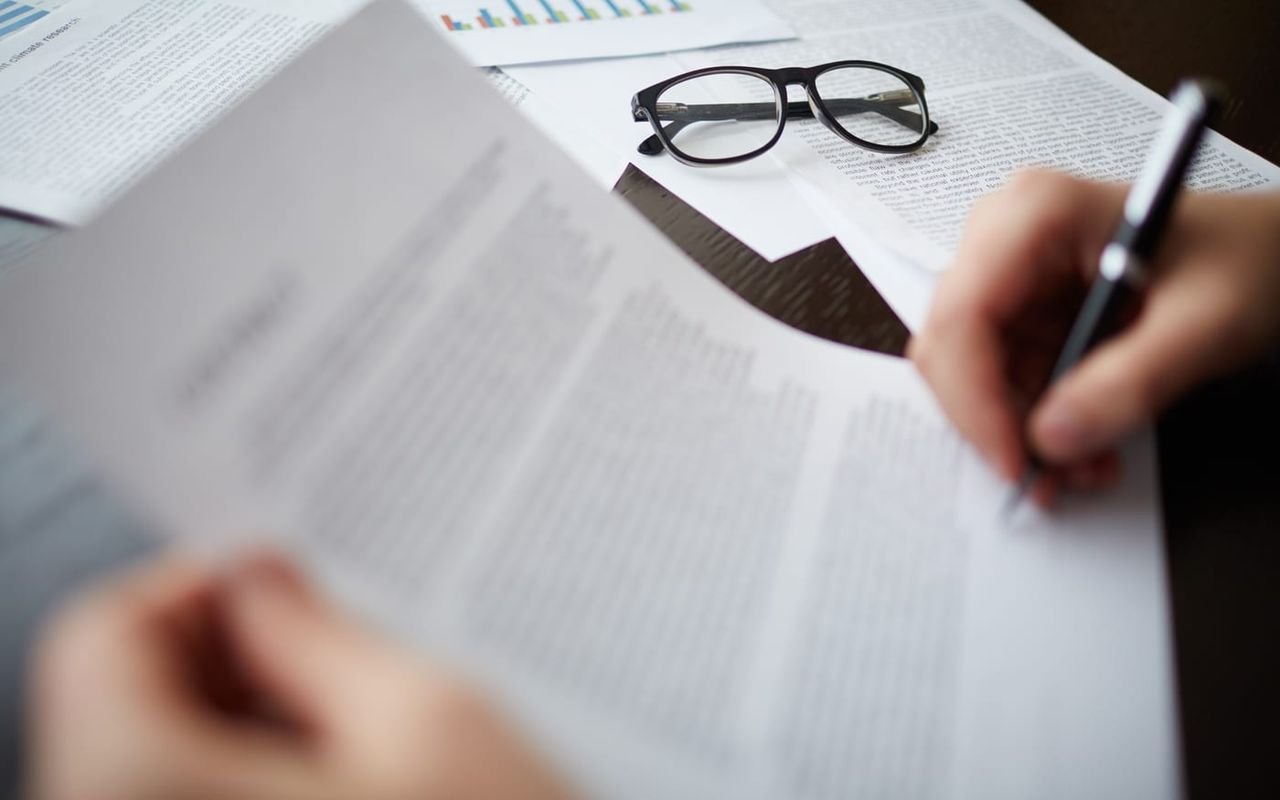 Unas gafas descansan sobre unos documentos apilados.