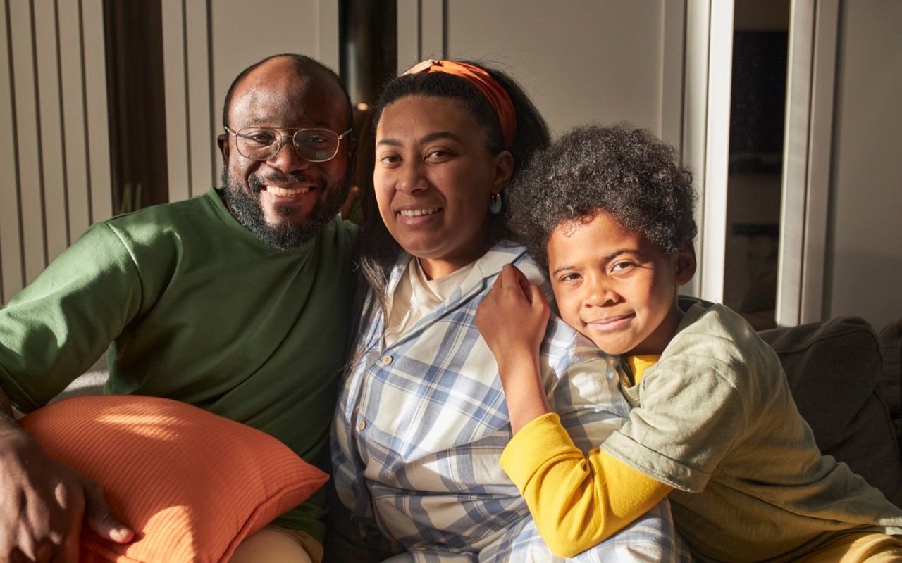 Una familia posa junta, sonriente.