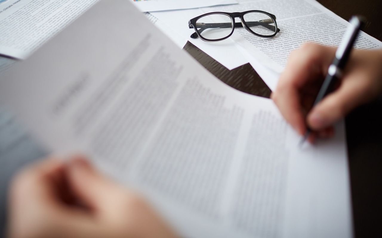 Unas gafas apoyadas sobre un montón de documentos.
