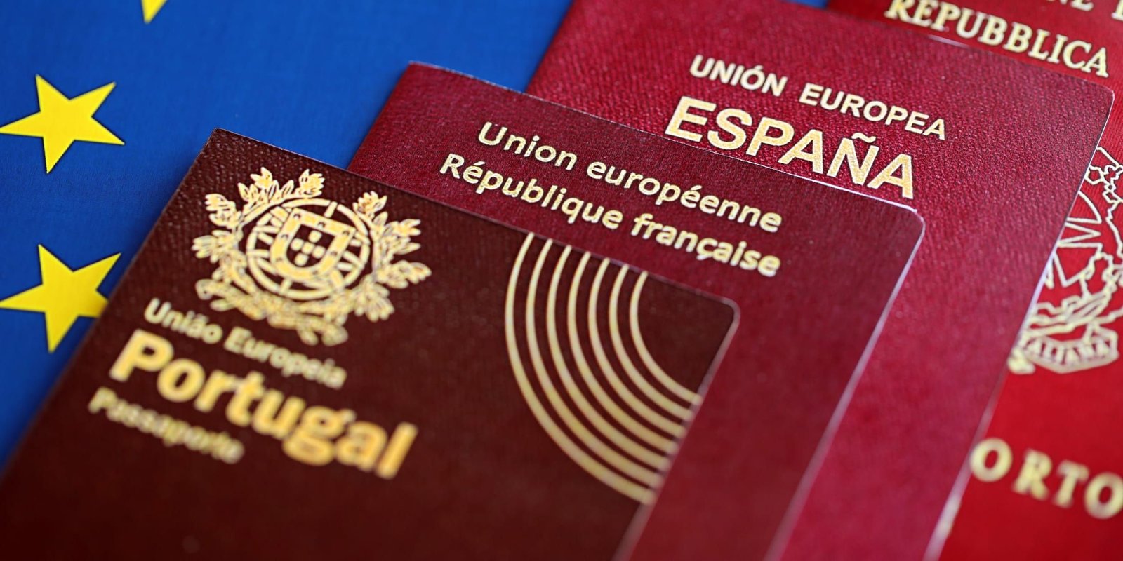 Varios pasaportes europeos sobre la bandera azul de la Unión Europea.