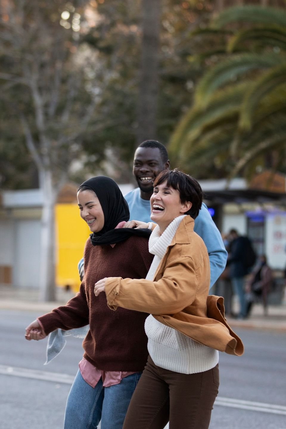 Varias personas caminan juntas y sonríen por la calle.