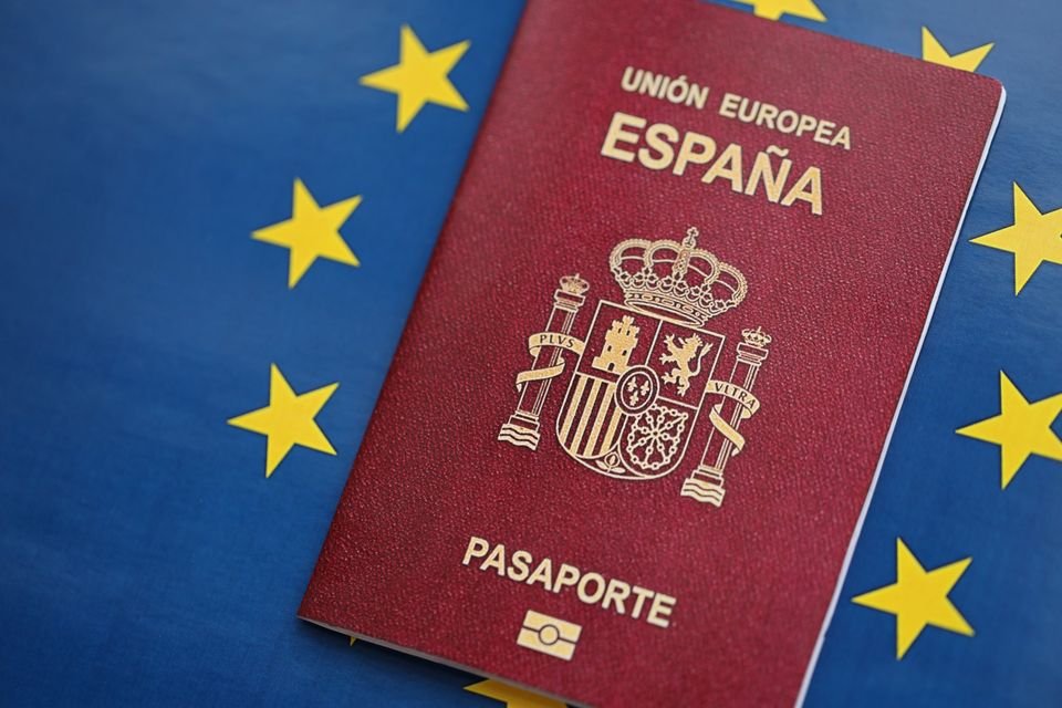 Un pasaporte español sobre la bandera azul de la Unión Europea.